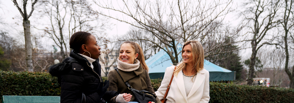 Three women sitting at a park in the winter discussing low libido in perimenopause